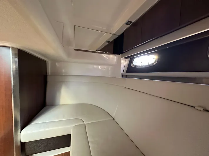  Yacht Photos Pics Interior cabin of 2016 Chaparral 337SSX boat with white seating and window.