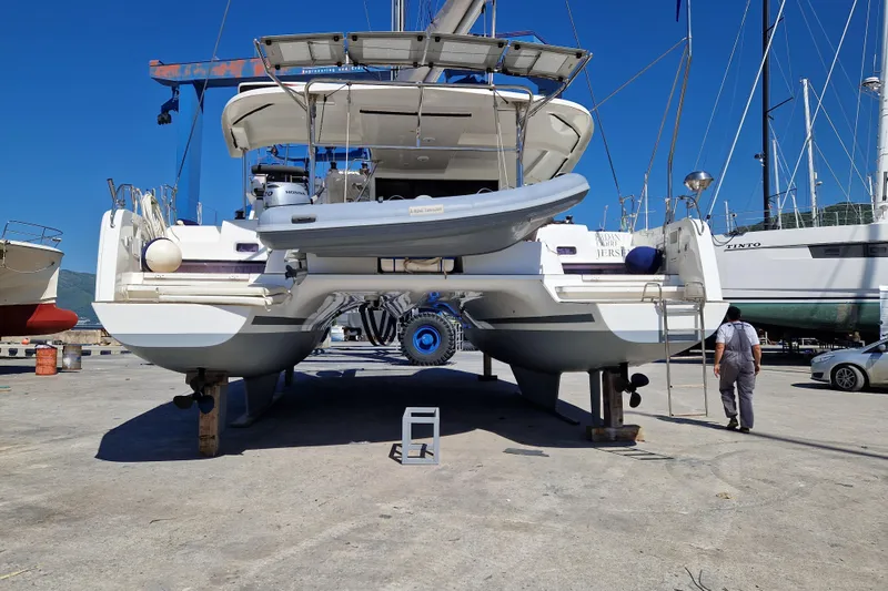 Eadan Doire Yacht Photos Pics 2017 Lagoon 42 catamaran on dry dock, with a dinghy attached, under clear blue sky.