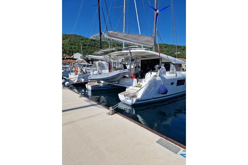 Eadan Doire Yacht Photos Pics 2017 Lagoon 42 catamaran docked at marina, clear blue sky, lush green hills.