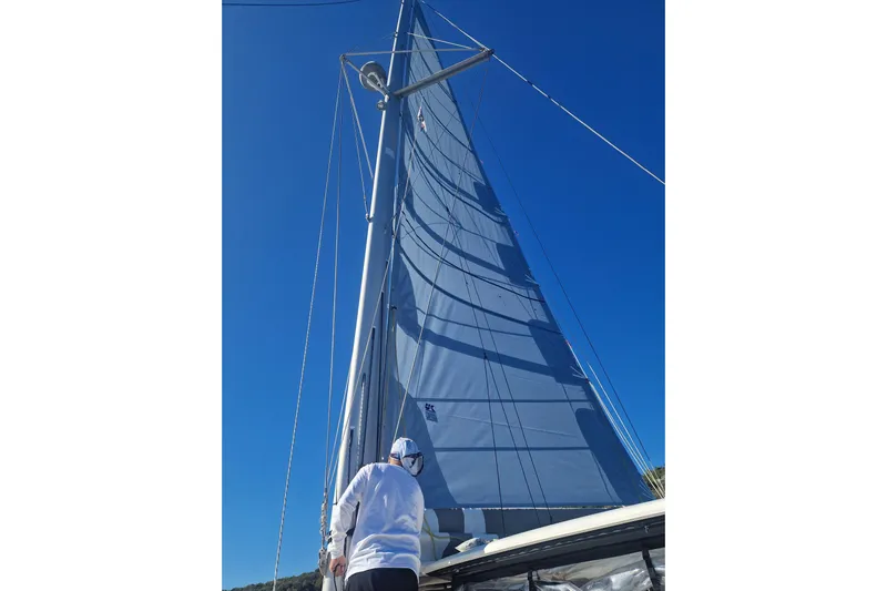 Eadan Doire Yacht Photos Pics Person on a 2017 Lagoon 42 sailboat, looking up at the tall mast and sail.