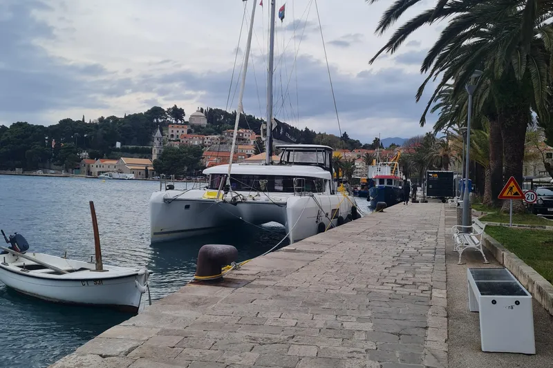 Eadan Doire Yacht Photos Pics 2017 Lagoon 42 catamaran docked at a scenic harbor with palm trees and historic buildings.