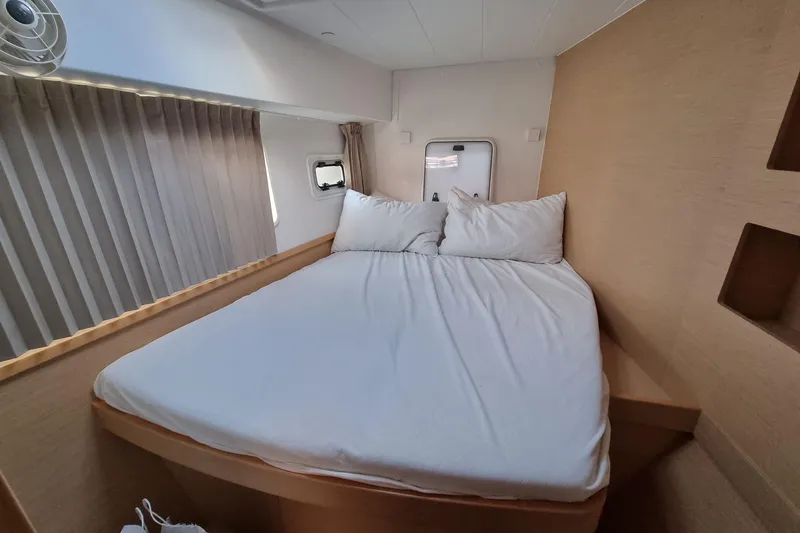 Eadan Doire Yacht Photos Pics Cozy bedroom interior of 2017 Lagoon 42 catamaran with white bedding and wooden accents.