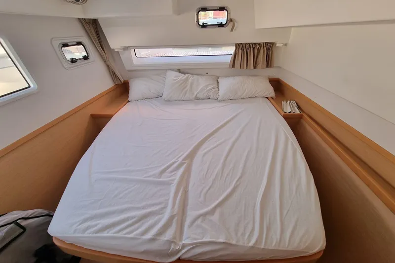 Eadan Doire Yacht Photos Pics Cozy bedroom interior of 2017 Lagoon 42 catamaran with white bedding and porthole windows.