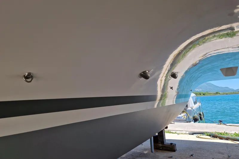 Eadan Doire Yacht Photos Pics Close-up of 2017 Lagoon 42 catamaran hull in dry dock, with scenic waterfront view.