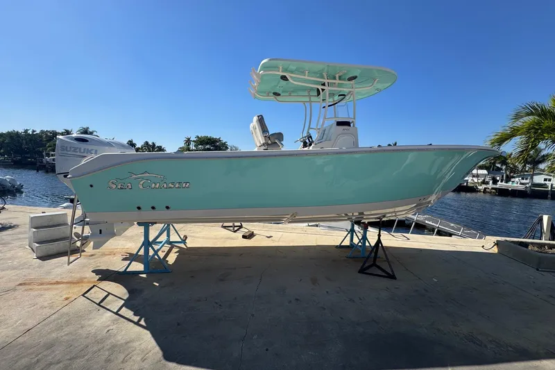 Yacht Photos Pics 2023 Sea Chaser 27 HFC CC boat on stands by waterfront, clear sky.