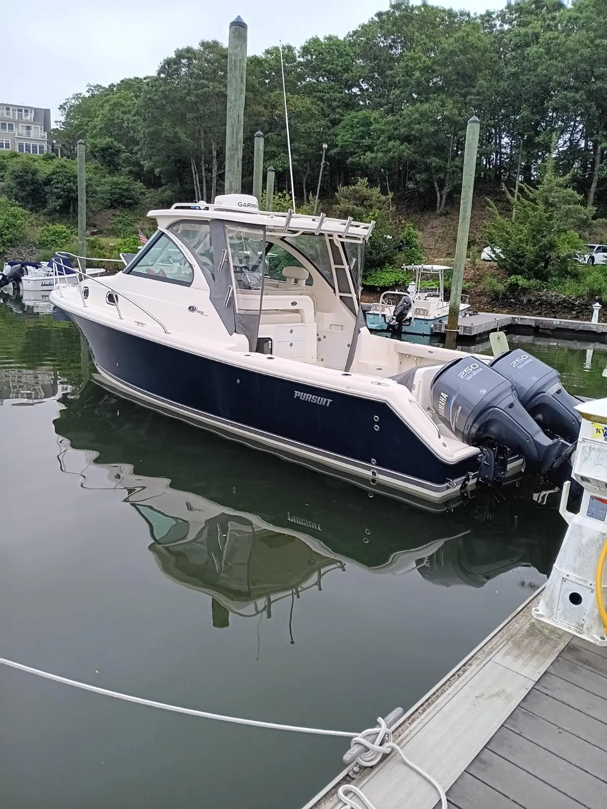 2009 Pursuit 310 OS boat docked in a marina with twin outboard engines.