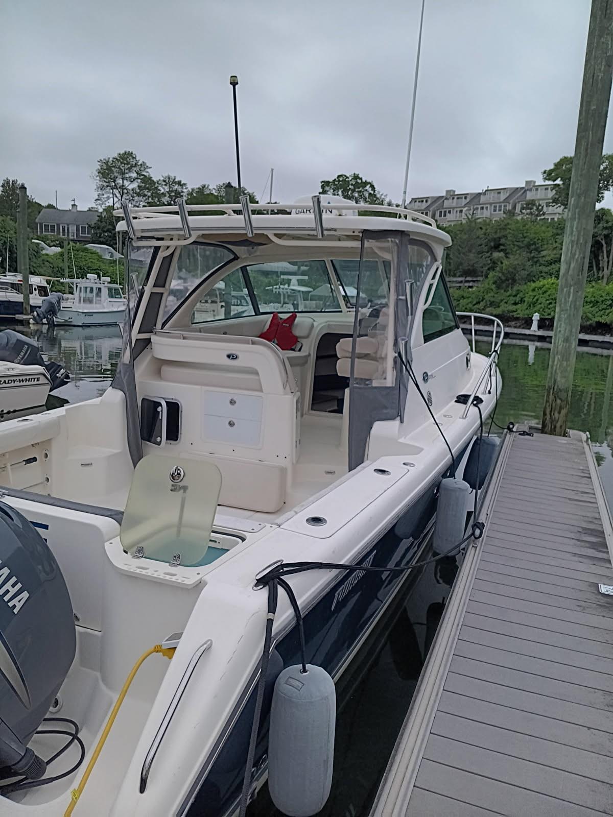 2009 Pursuit 310 OS boat docked at marina with Yamaha engine.