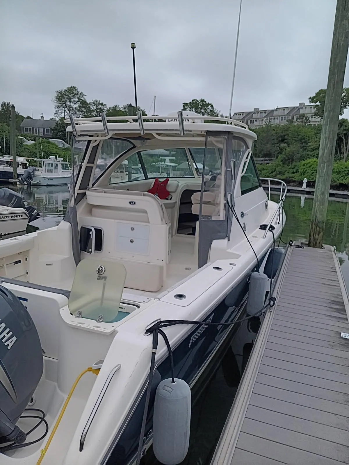 2009 Pursuit 310 OS boat docked at marina with Yamaha engine.