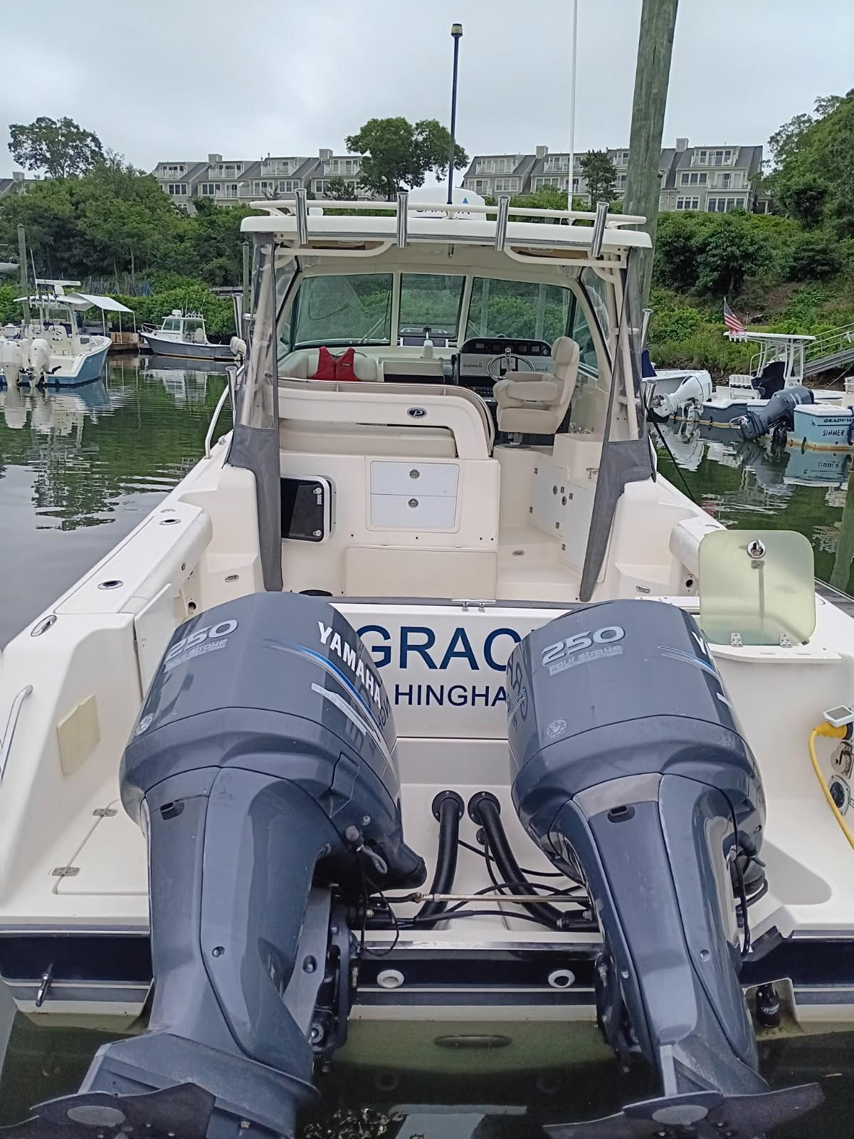2009 Pursuit 310 OS boat with twin Yamaha 250 engines docked in a marina.