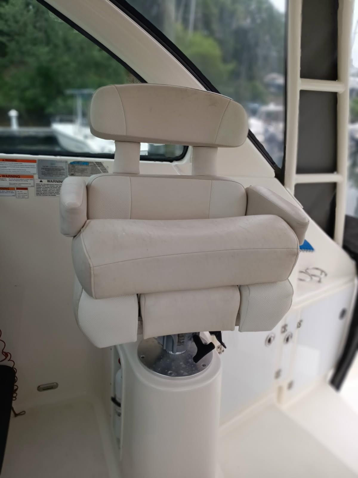 Captain's chair on 2009 Pursuit 310 OS boat, featuring plush white upholstery.