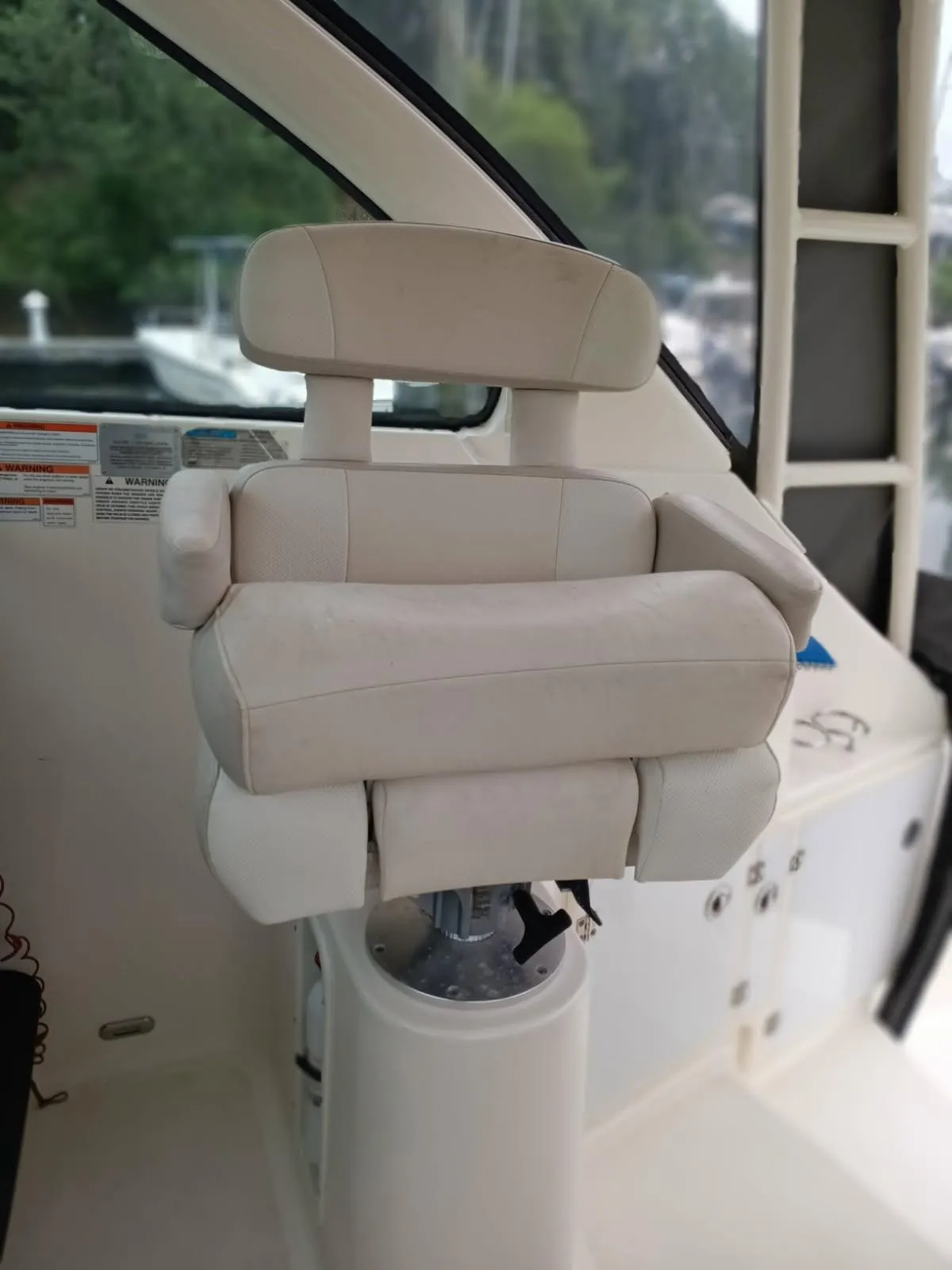 Captain's chair on 2009 Pursuit 310 OS boat, featuring plush white upholstery.