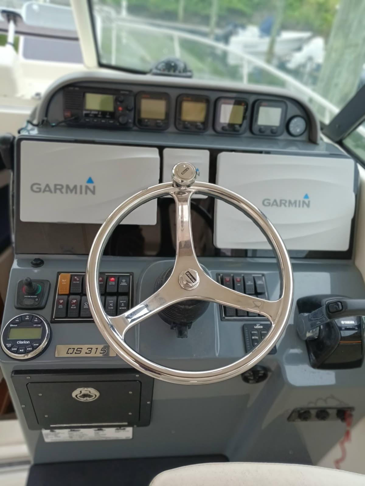 2009 Pursuit 310 OS boat dashboard with Garmin navigation and steering wheel.