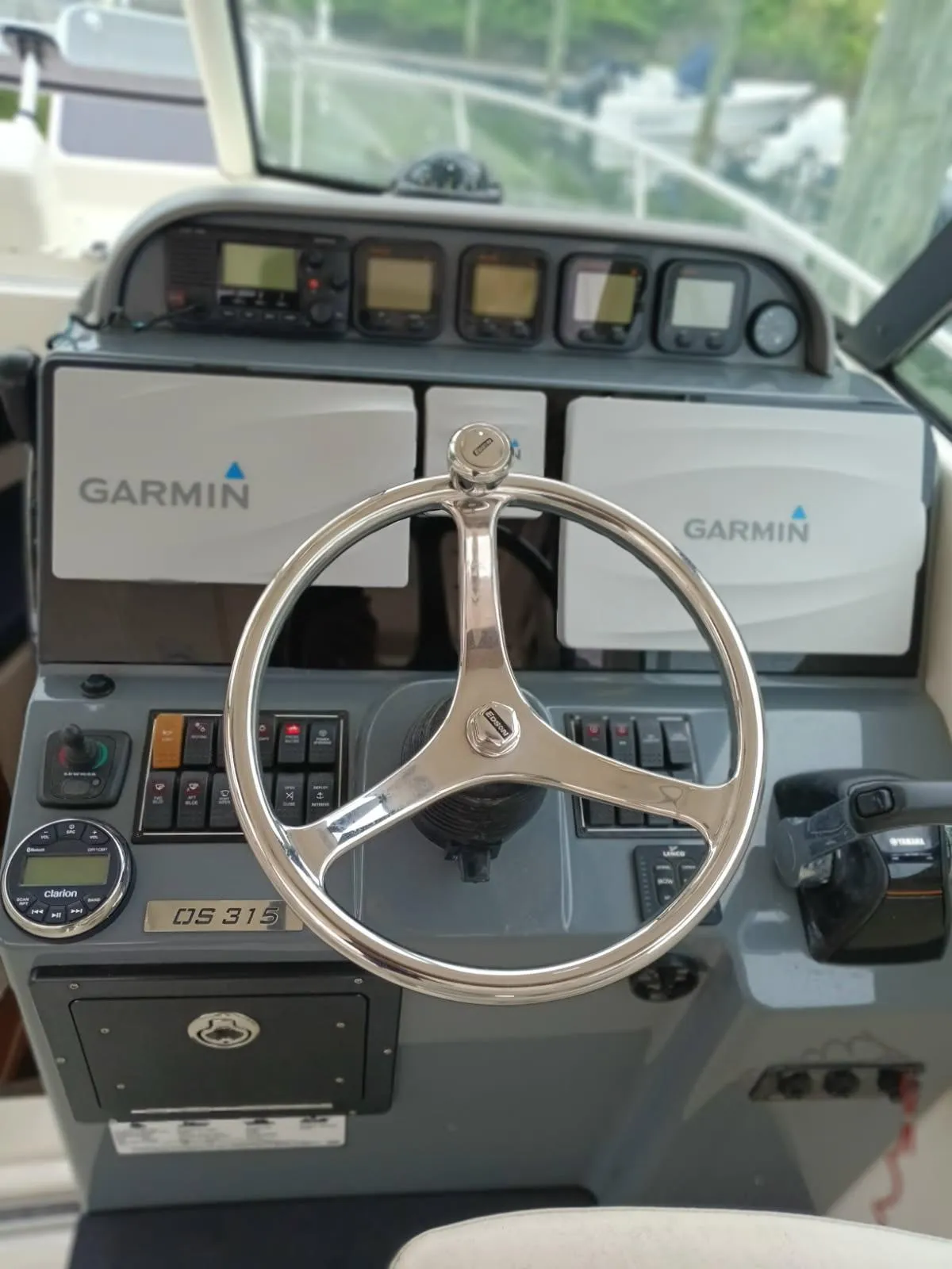 2009 Pursuit 310 OS boat dashboard with Garmin navigation and steering wheel.