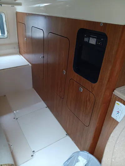 Gracie Yacht Photos Pics Interior of a 2009 Pursuit 310 OS boat, featuring wooden cabinetry and control panel.