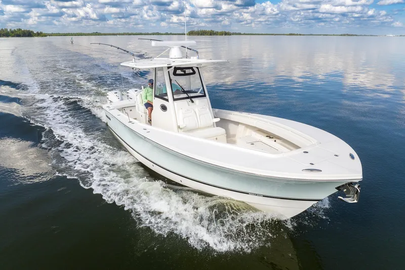  Yacht Photos Pics 2021 Regulator 31 boat cruising on calm water under a partly cloudy sky.