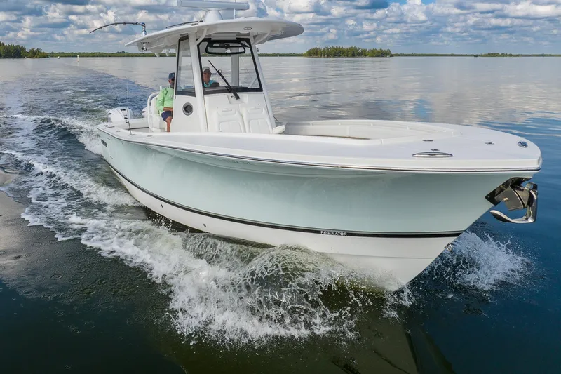  Yacht Photos Pics 2021 Regulator 31 boat cruising on calm water under a partly cloudy sky.