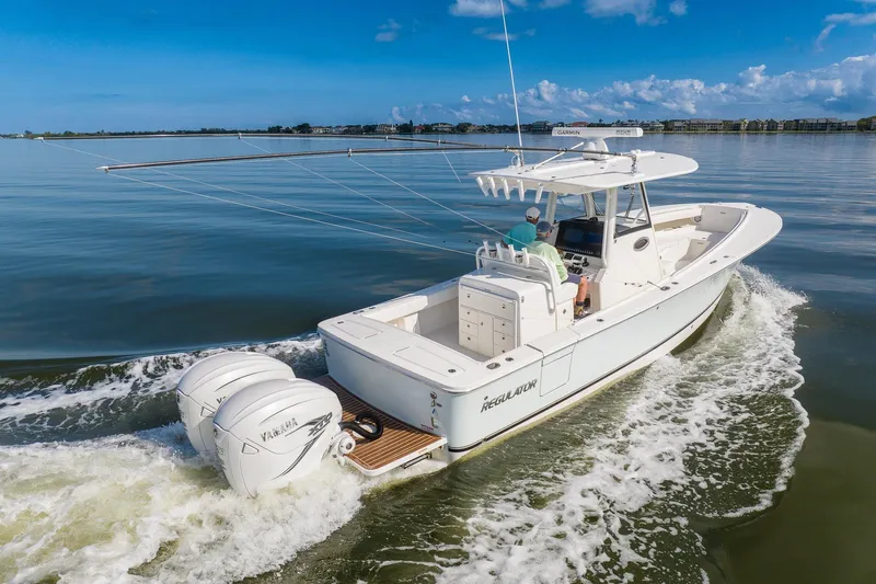  Yacht Photos Pics 2021 Regulator 31 boat cruising on calm waters under a clear blue sky.