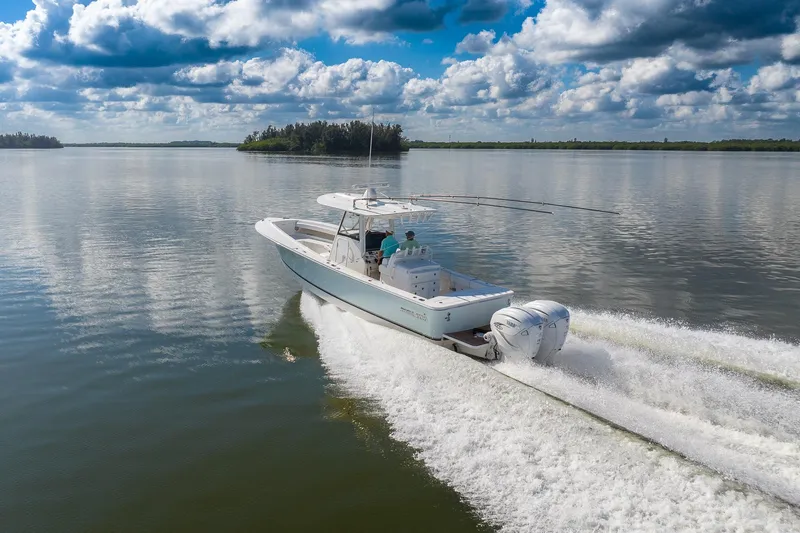  Yacht Photos Pics 2021 Regulator 31 boat cruising on calm water under a partly cloudy sky.