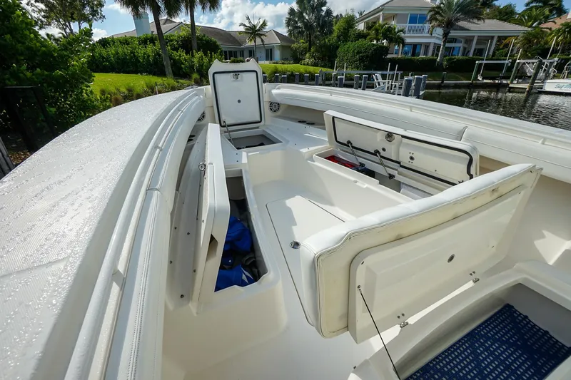  Yacht Photos Pics 2021 Regulator 31 boat interior with open storage compartments, docked near waterfront homes.