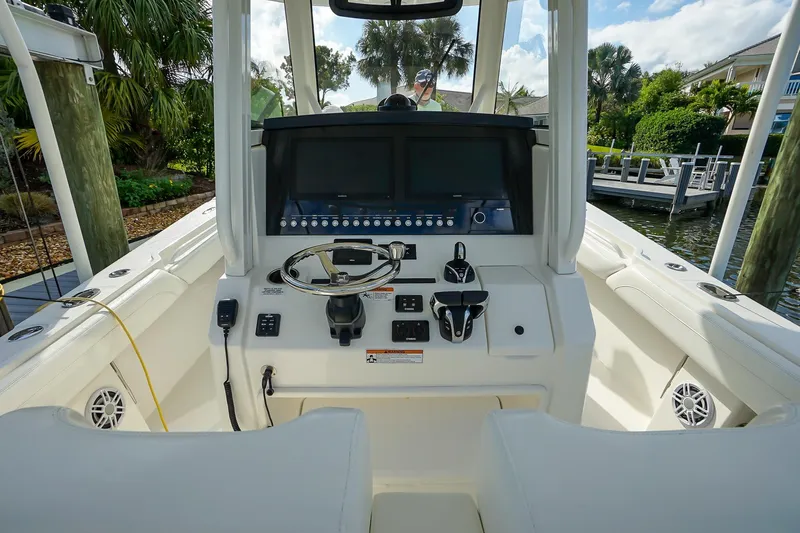  Yacht Photos Pics 2021 Regulator 31 boat cockpit with steering wheel and control panel.