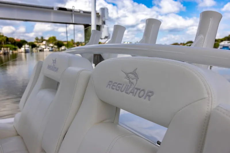  Yacht Photos Pics 2021 Regulator 31 boat with white leather seats and logo, under a blue sky.