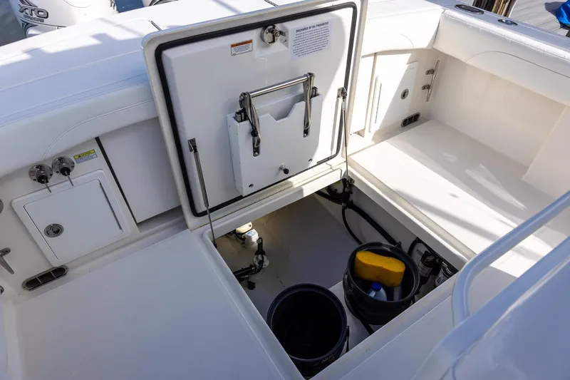  Yacht Photos Pics 2021 Regulator 31 boat storage compartment with open hatch and cleaning supplies.
