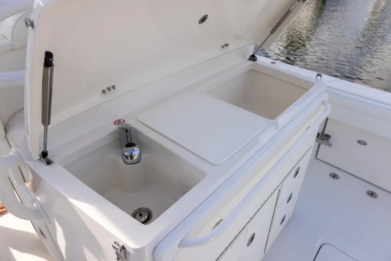  Yacht Photos Pics 2021 Regulator 31 boat sink and storage area with open lid, dockside view.
