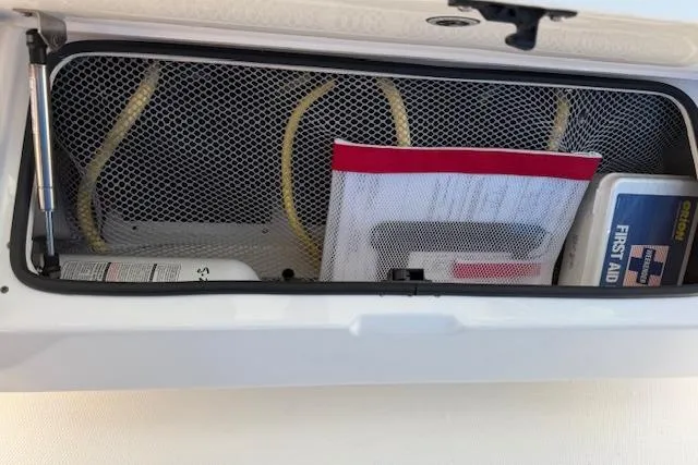  Yacht Photos Pics Open storage compartment on 2021 Regulator 31 boat with first aid kit and safety equipment.