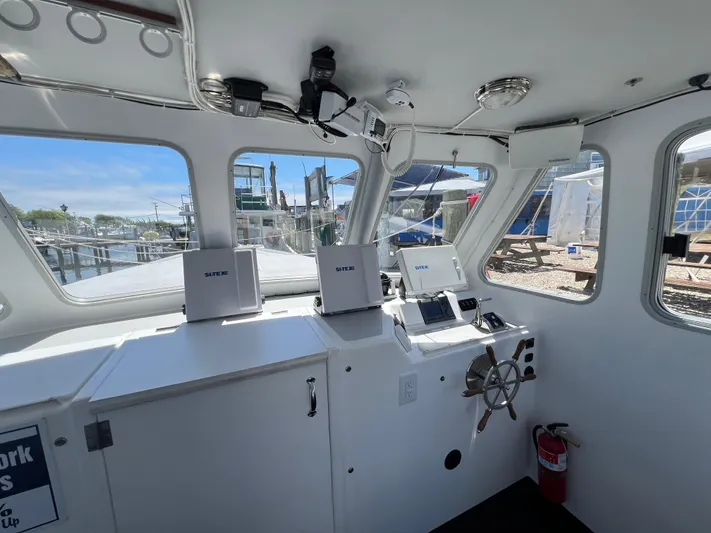 Lady Grace Yacht Photos Pics Interior of 2022 Wesmac 38 boat with navigation equipment and steering wheel.