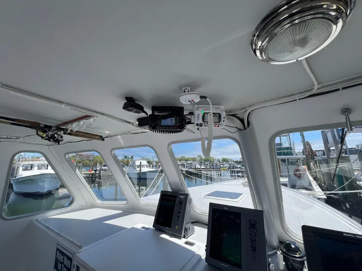 Lady Grace Yacht Photos Pics Interior view of 2022 Wesmac 38 boat with navigation equipment and marina background.