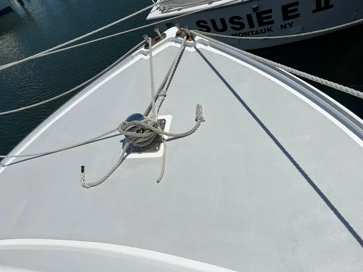Lady Grace Yacht Photos Pics Bow of 2022 Wesmac 38 boat with ropes, docked near another vessel.