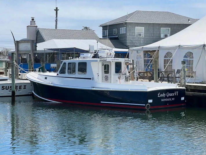 Lady Grace Yacht Photos Pics Wesmac 38 boat, 2022 model, docked near waterfront buildings and tents.