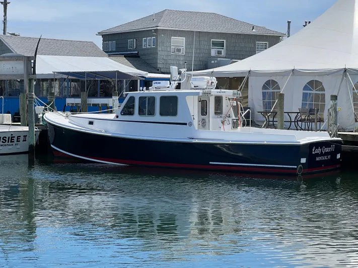 Lady Grace Yacht Photos Pics 2022 Wesmac 38 boat docked near waterfront buildings and tents.