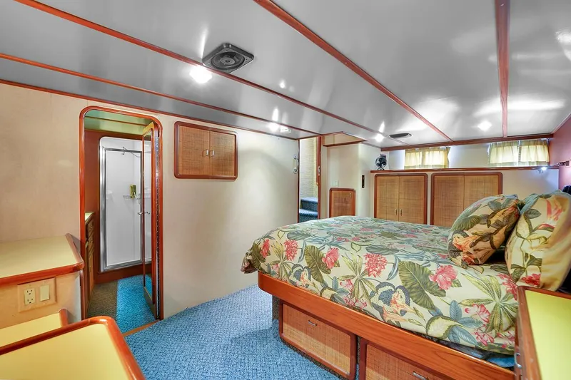 Stealin Time Yacht Photos Pics Luxurious bedroom interior of 1991 Jones-Goodell Yachtfish with floral bedding and wooden accents.