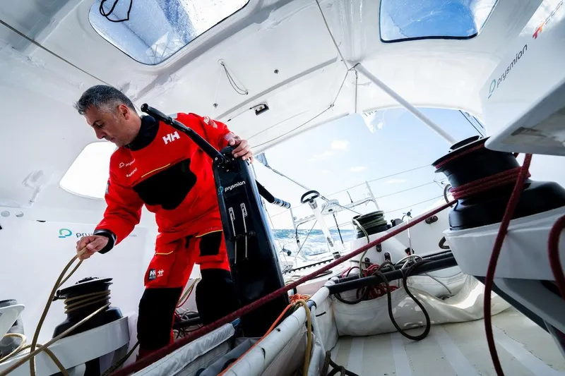Prysmian Yacht Photos Pics Sailor managing ropes on a 2015 Multiplast Imoca 60 yacht deck.