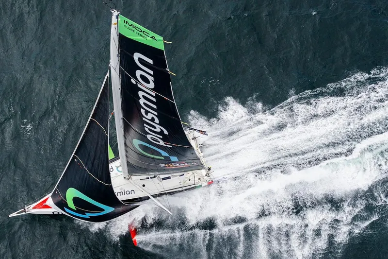 Prysmian Yacht Photos Pics Aerial view of 2015 Multiplast Imoca 60 sailboat racing on ocean waves.