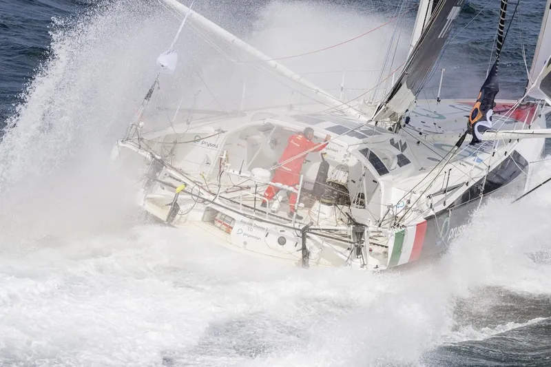 Prysmian Yacht Photos Pics Sailing yacht Imoca 60 by Multiplast, 2015, navigating rough seas with crew on deck.