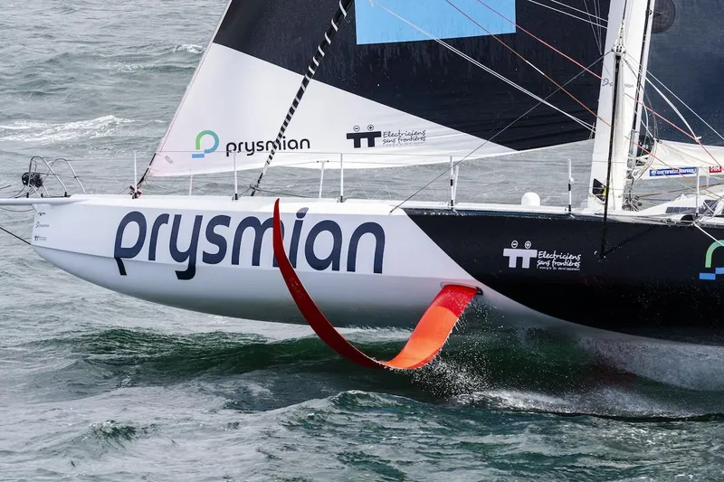 Prysmian Yacht Photos Pics Sailing yacht "Prysmian" Imoca 60 by Multiplast, 2015, cutting through ocean waves.