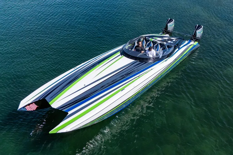  Yacht Photos Pics 2022 MTI 390X speedboat with vibrant stripes on clear water.