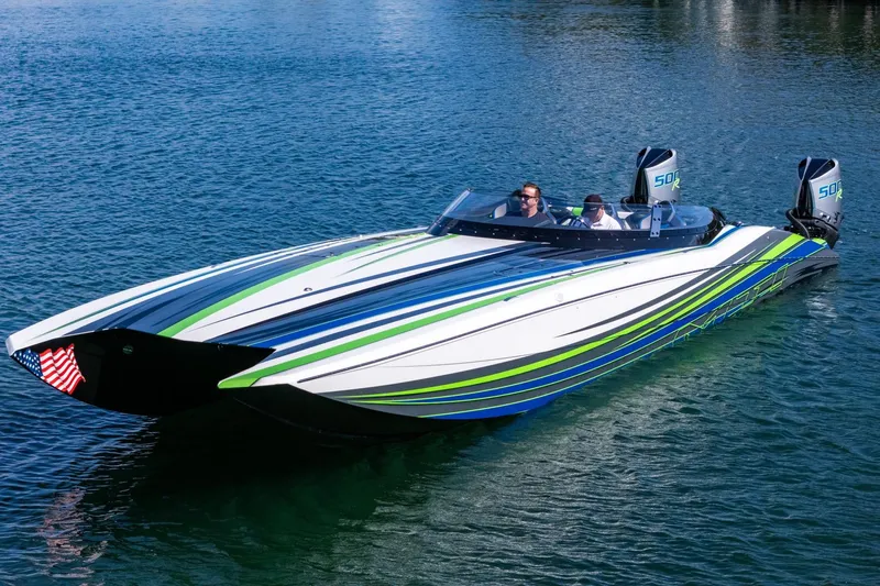  Yacht Photos Pics 2022 MTI 390X speedboat with vibrant stripes on a calm blue lake.
