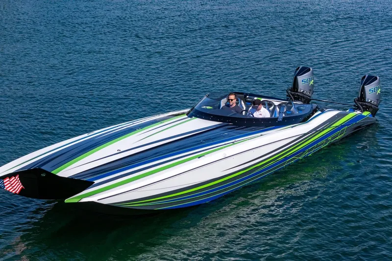  Yacht Photos Pics 2022 MTI 390X speedboat with vibrant blue and green stripes on calm water.