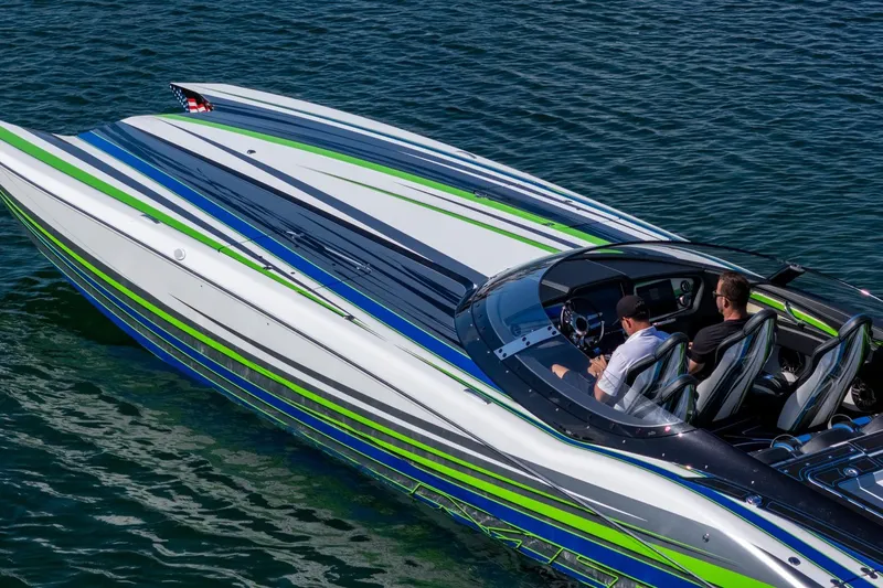  Yacht Photos Pics 2022 MTI 390X speedboat with vibrant stripes cruising on clear blue water.