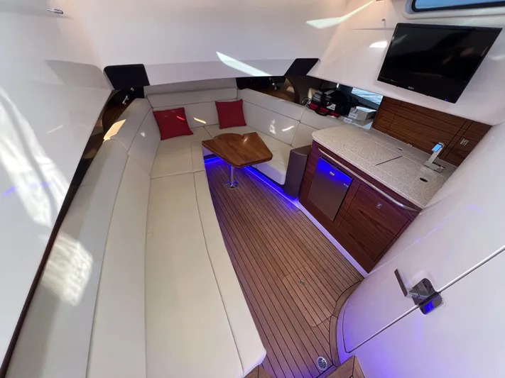  Yacht Photos Pics Luxurious interior of 2023 Boston Whaler 420 Outrage with seating, kitchenette, and ambient lighting.
