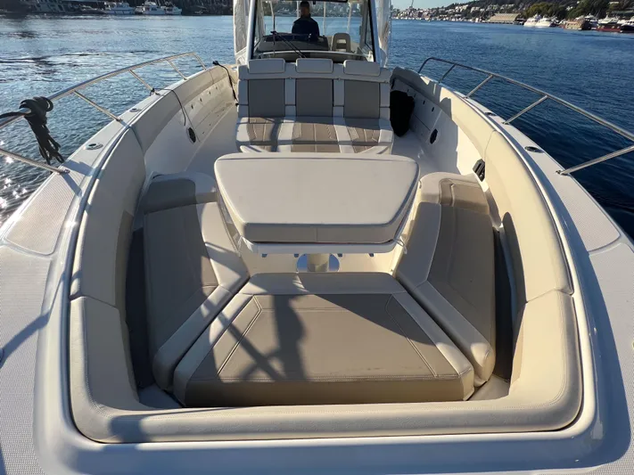  Yacht Photos Pics 2023 Boston Whaler 420 Outrage boat interior with seating and table on calm water.