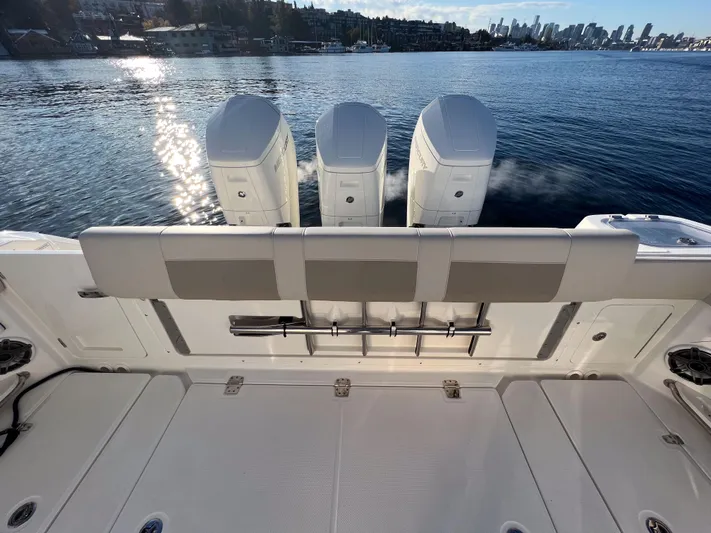  Yacht Photos Pics 2023 Boston Whaler 420 Outrage boat with triple engines on a calm waterfront.