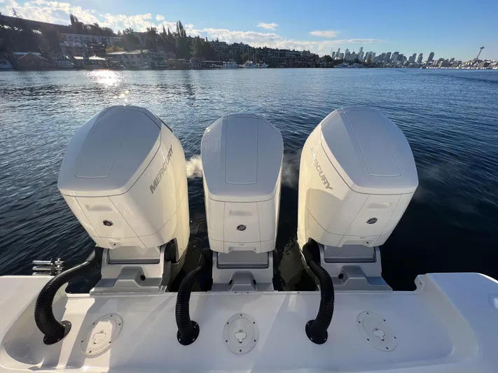  Yacht Photos Pics Triple Mercury outboard engines on a 2023 Boston Whaler 420 Outrage, with city skyline backdrop.
