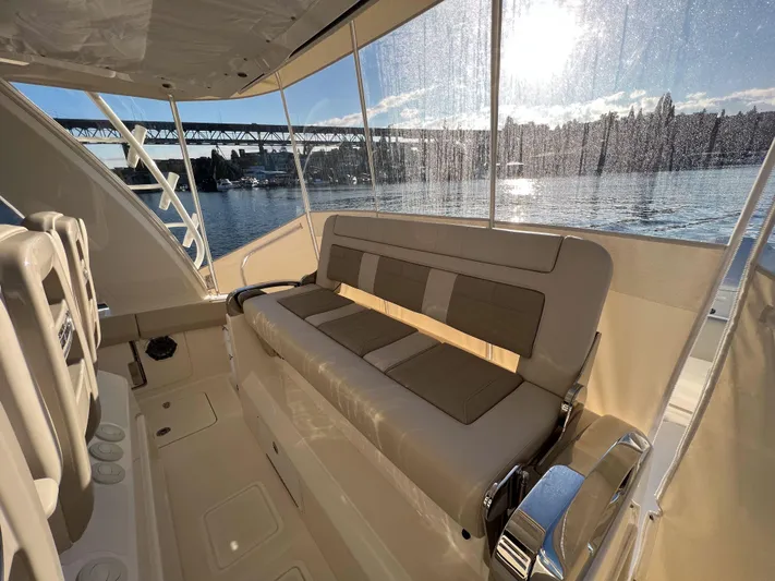  Yacht Photos Pics 2023 Boston Whaler 420 Outrage interior with seating, overlooking a scenic waterfront view.