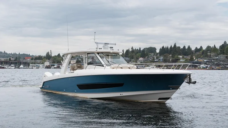  Yacht Photos Pics 2023 Boston Whaler 420 Outrage boat on water, cloudy sky, scenic background.