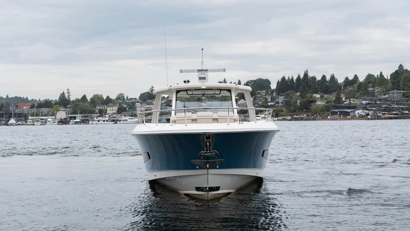  Yacht Photos Pics 2023 Boston Whaler 420 Outrage boat on water, front view, with scenic background.