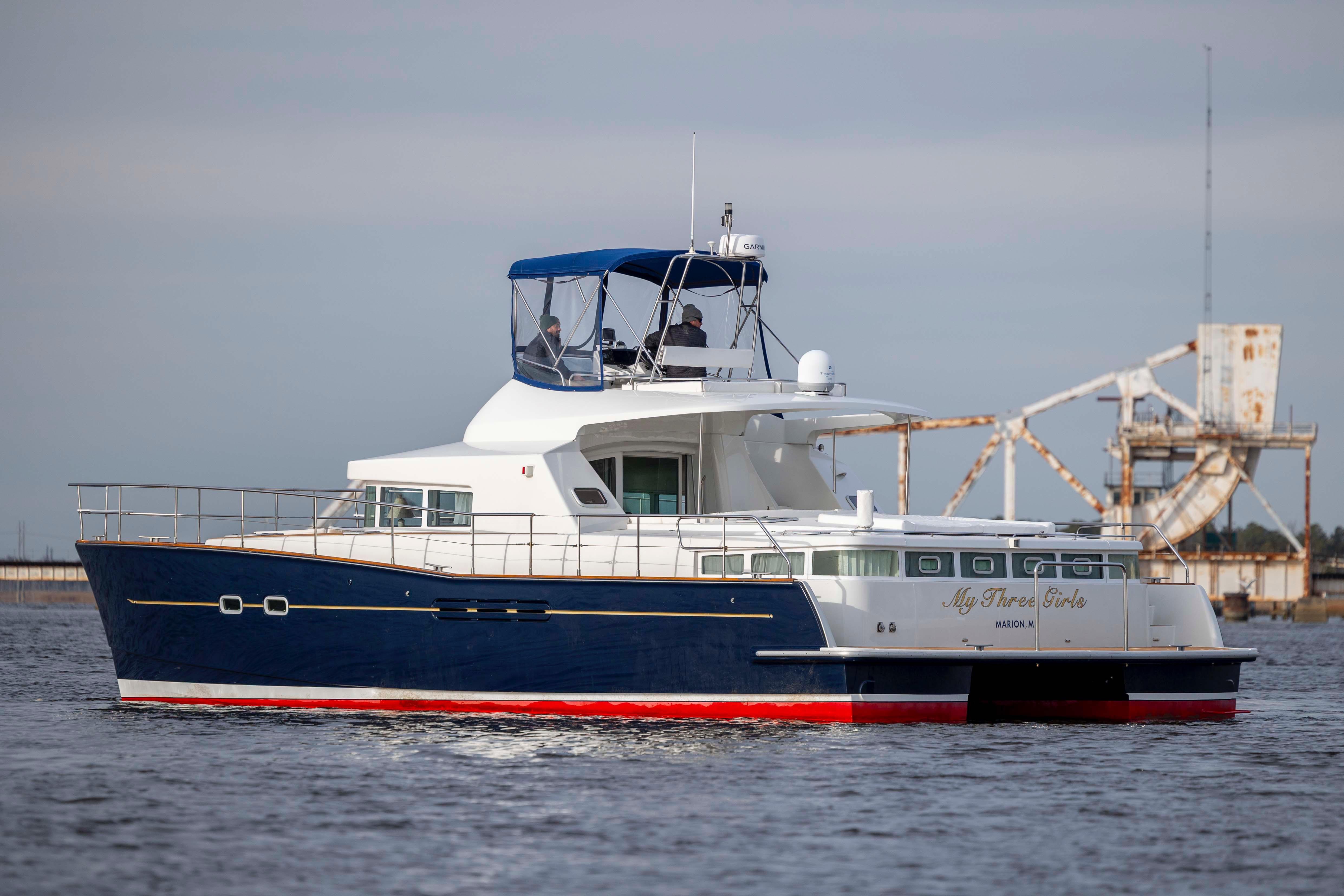 2004 Lagoon 43 PC yacht cruising on water, featuring a sleek blue and white design.